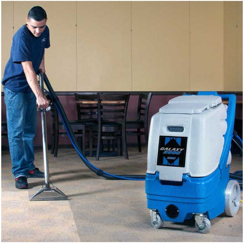 Man Cleaning the Carpet Using Wand with EDIC Galaxy 2000IX-HR 12 Gallon Carpet Extractor - 220 PSI Pump for Deep Results